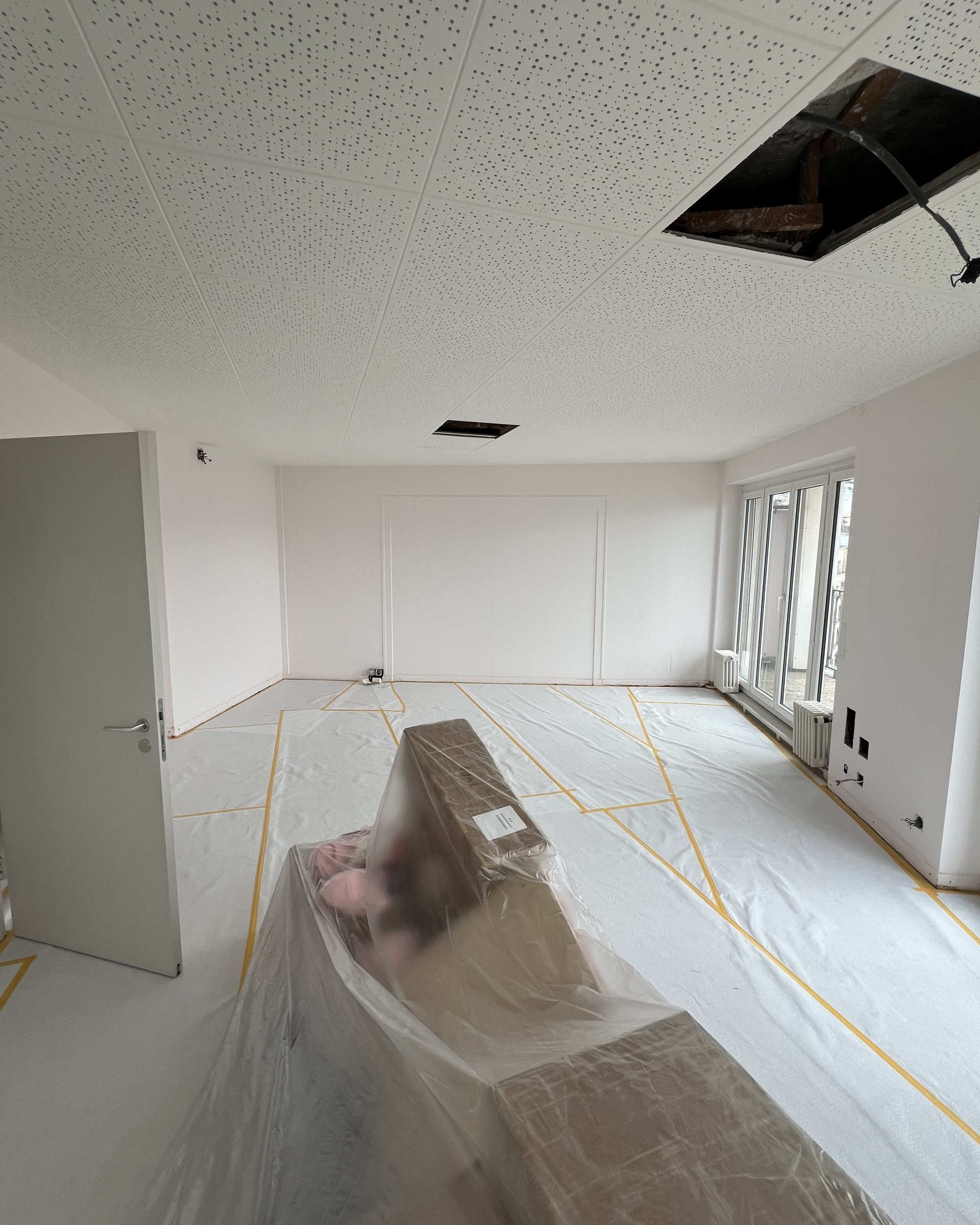 Empty room with protected floor and open ceiling hatch