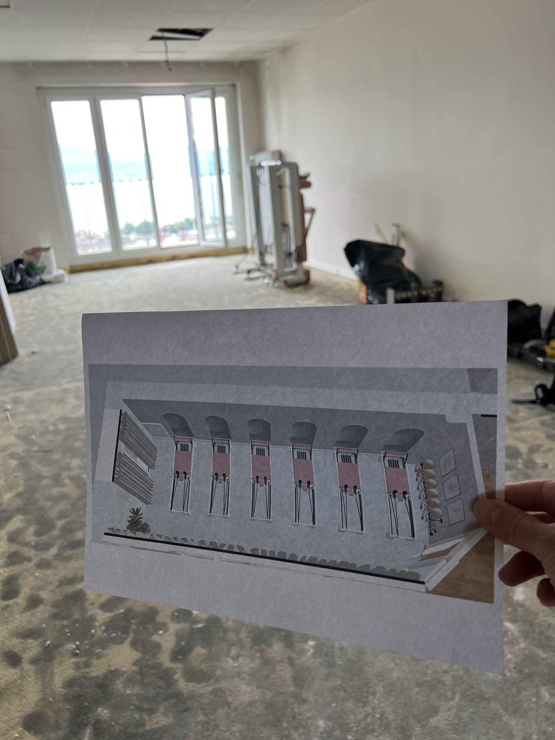 Printed render of the reformer studio held up in the stripped room